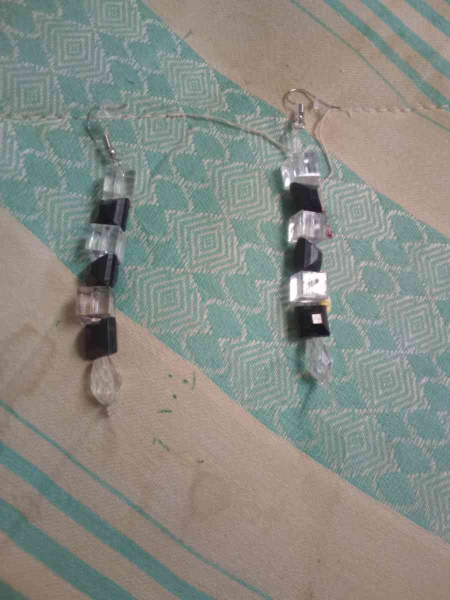 a religious wall hanging and two pairs of hand made earrings