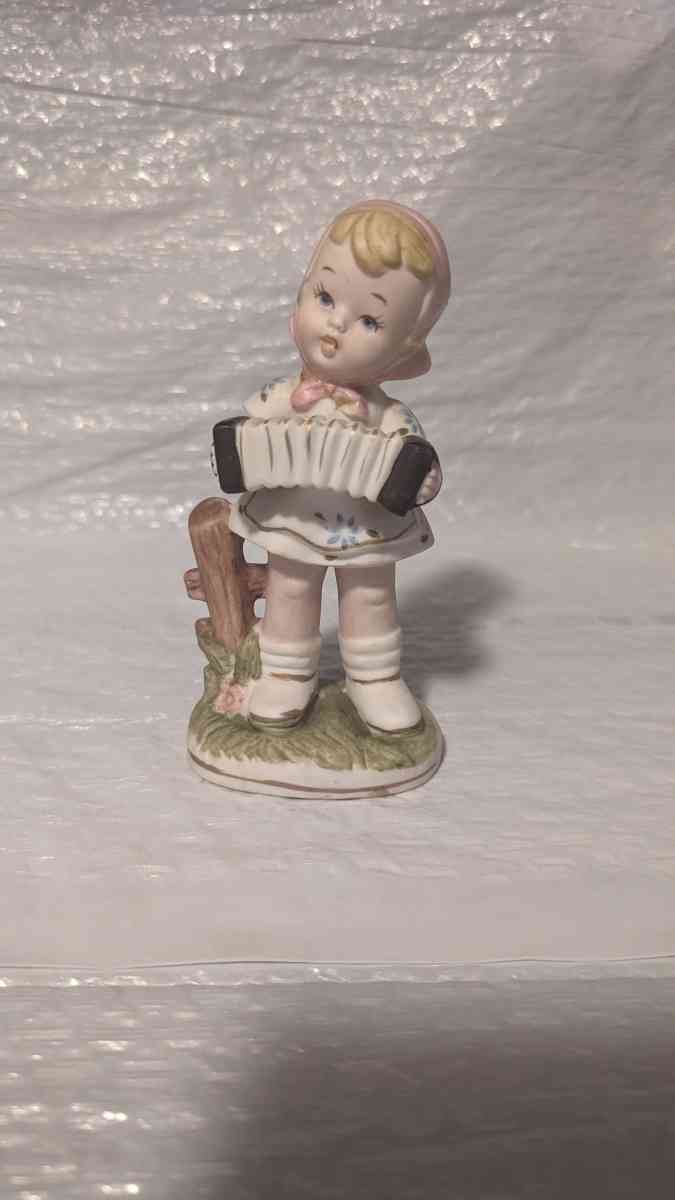 A Little Girl Playing an Accordion with a White Dress