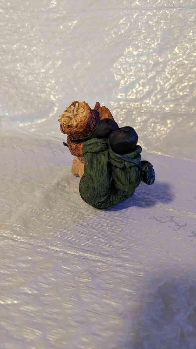 Resin Scarecrow Laying Down With Legs Bent Holding A Crow