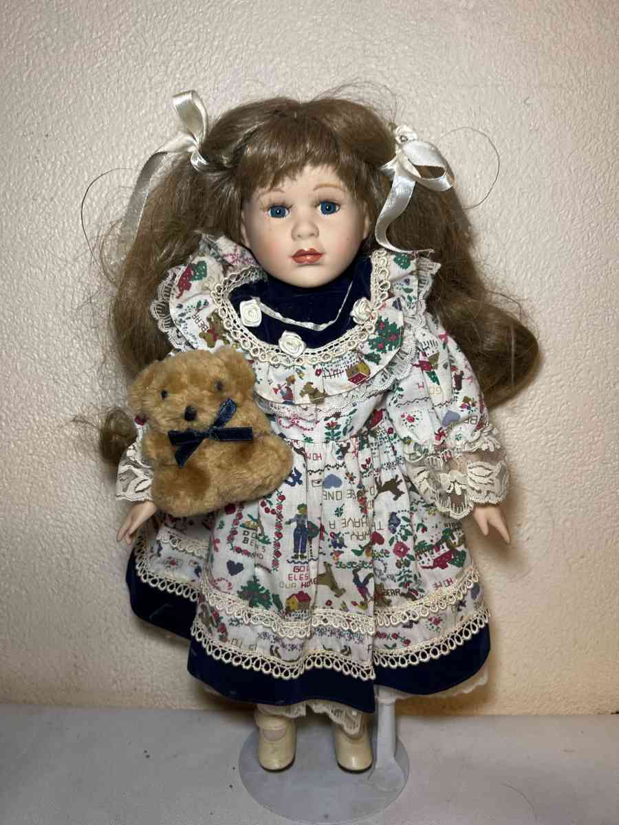 vintage porcelain doll hoding stuffed bear