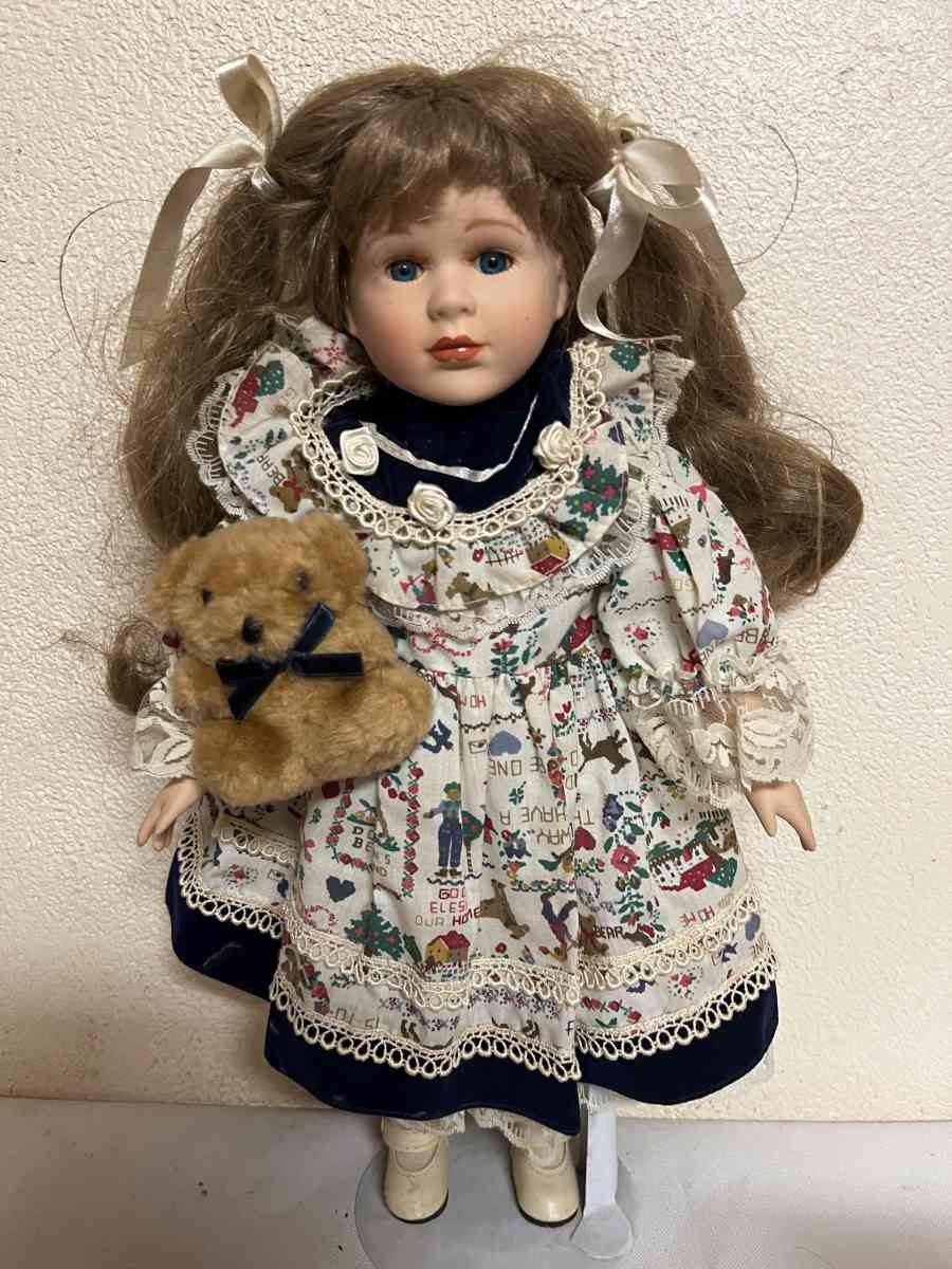 vintage porcelain doll hoding stuffed bear